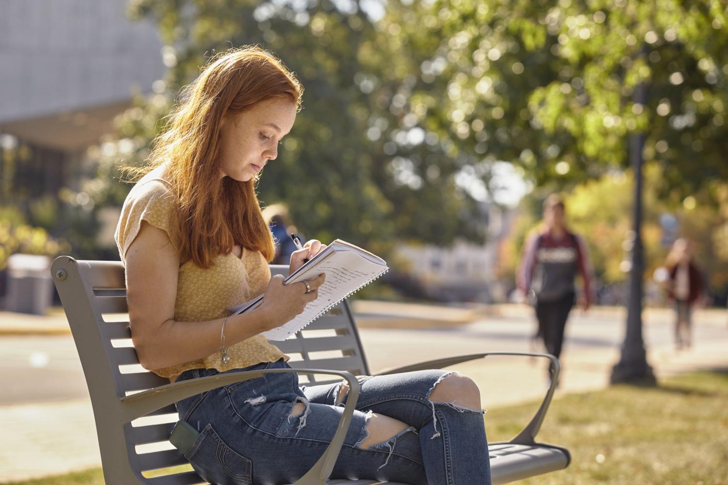 一位<a href='http://bulletin.ansafe.net'>全球十大赌钱排行app</a>学院的学生在校园里的长椅上读书.